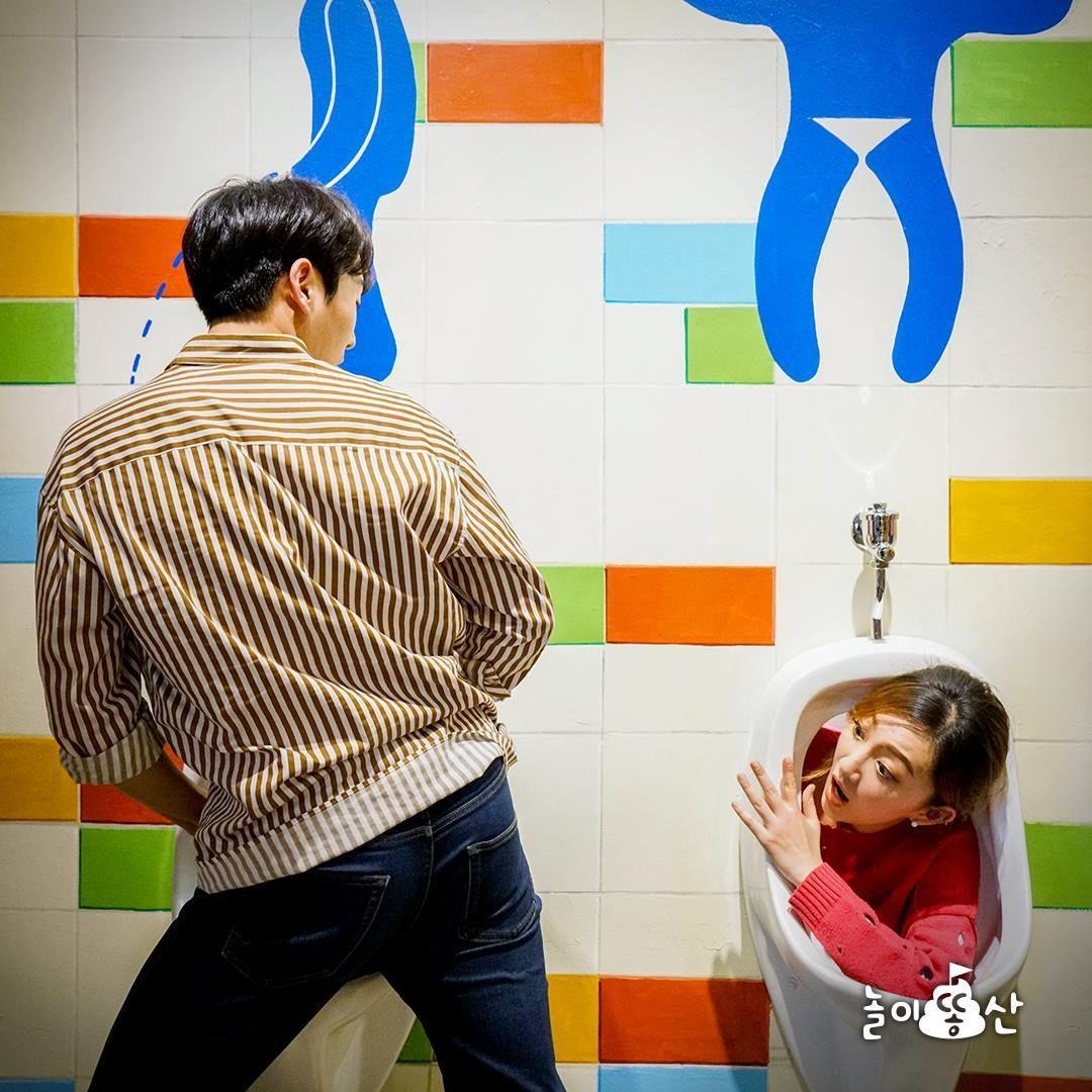 首爾大便體驗展覽，兩位遊客在3D立體動作背景牆前合影。